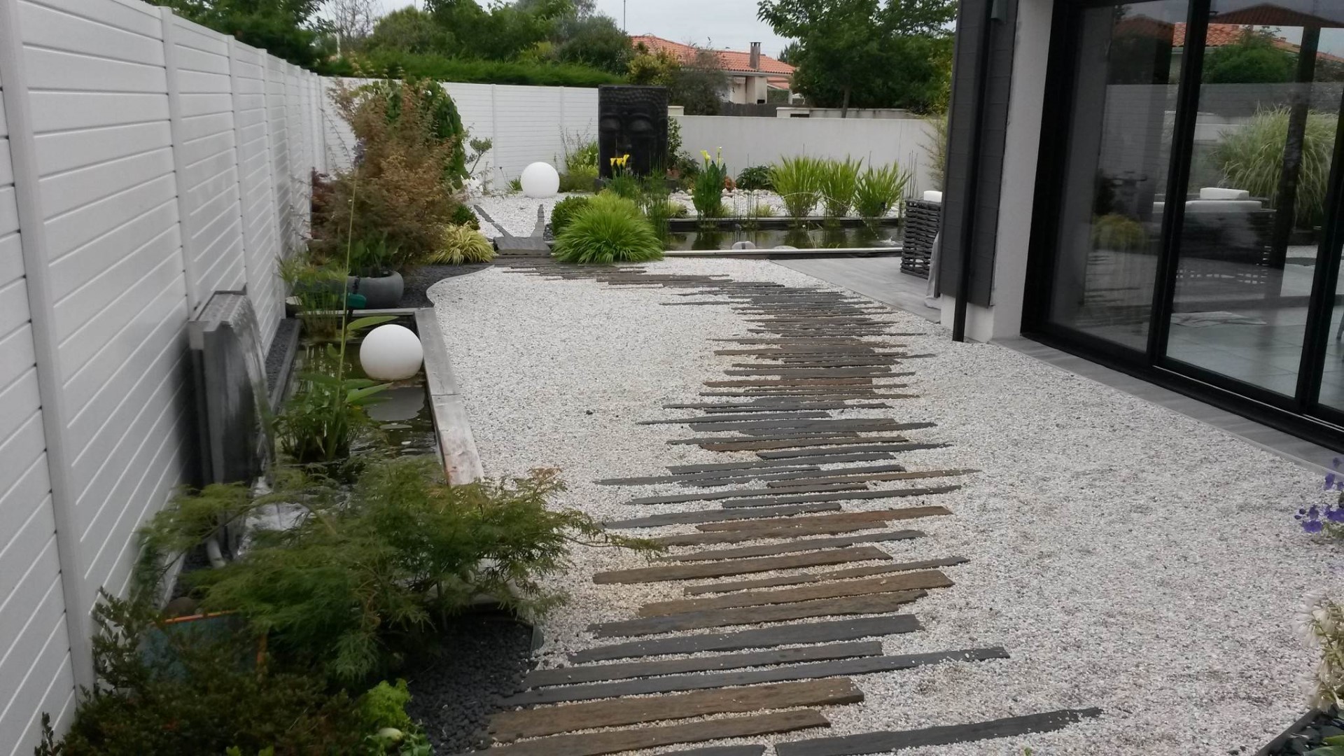 A gauche le petit bassin avec sa lame d’eau , et au centre l’allée en barrettes de schiste qui mène au grand bassin A gauche le petit bassin avec sa lame d'eau , et au centre l'allée en barrettes de schiste qui mène au grand bassin