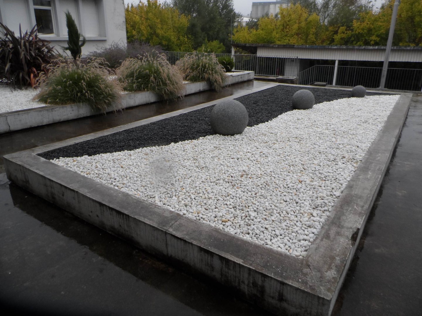Le yin et le yang en galets de marbre blanc, pétales d’ardoise et sphères de granit Le yin et le yang en galets de marbre blanc, pétales d'ardoise et sphères de granit