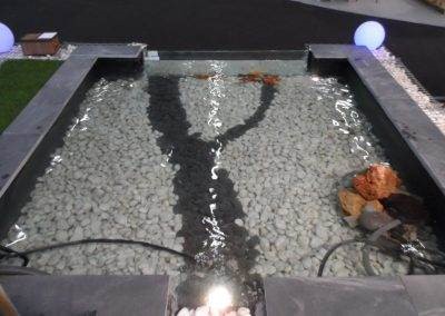 Bassin vitré, galets de marbre blanc et basalte en décoration sur le fond, dalle de filita sur le pourtour