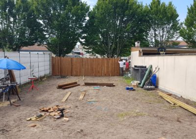 Au fond du jardin, pose d'une clôture asymétrique en pin