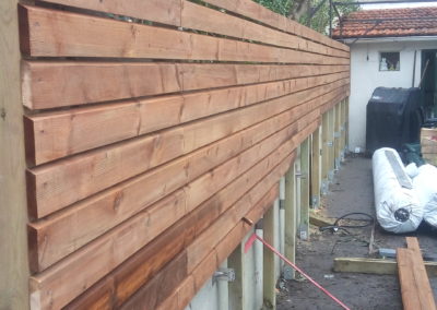 Installation du bardage en liteaux pour couvrir le mur