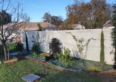 Massif à l'arrière du jardin, mise en place de fils de tension sur le mur pour faire courir le jasmin.